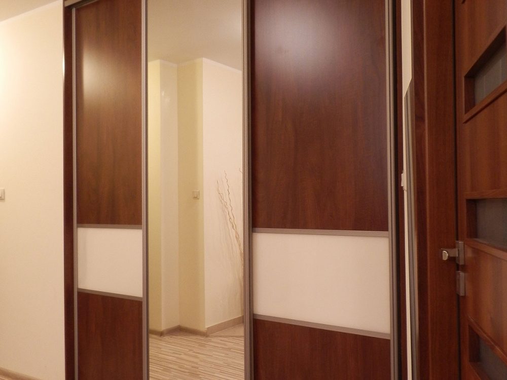 Garderoba z drzwiami przesuwnymi, przestronna wnęka z półkami i drążkami