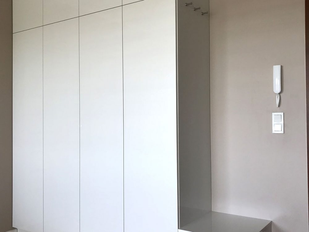 Biała szafa z drzwiami rozwieranymi i siedziskiem
